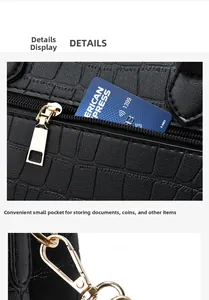 Detail showing the black croc-embossed texture and gold zipper hardware of the handbag