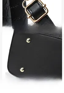 Detailed macro view of crocodile pattern leather with gold hardware and protective base studs