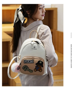 Close-up of cute bear embroidery and sequin patch on a stylish mini backpack