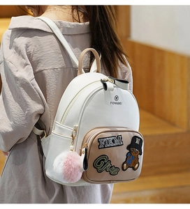 Close-up of mini cream backpack featuring bear sequin embroidery and slim straps