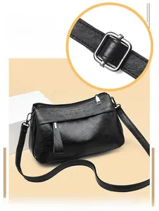 Detail of black pebbled leather shoulder bag showing the silver buckle and side view