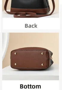 Detailed back and bottom view of two-tone leather bucket bag with gold metal feet