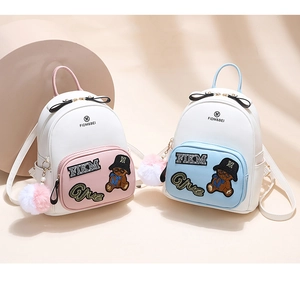 Detailed view of mini PU leather backpacks with bear embroidery and pom-pom charms