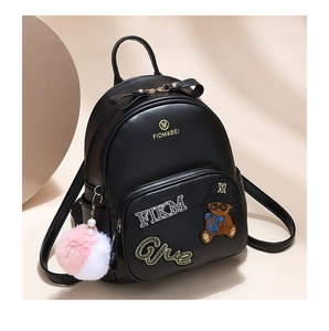 Detail of mini black PU leather backpack with cartoon bear embroidery and plush ball charm