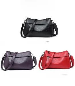 Three-color display of textured faux leather crossbody bags in black, purple and red