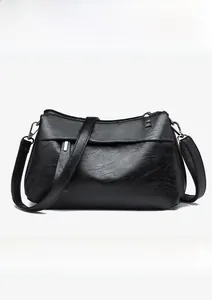 Front view of black pebble leather crossbody bag with silver hardware on white background