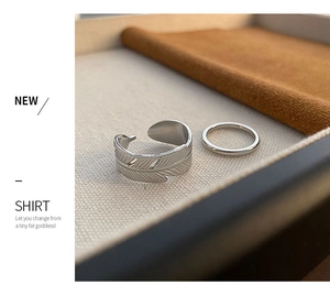 Macro shot of silver feather textured adjustable ring and minimalist thin smooth band