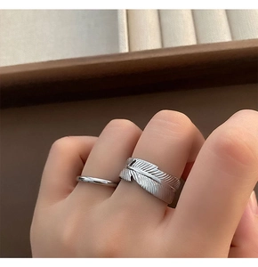 Detail of silver feather ring and minimalist band on velvet jewelry display case