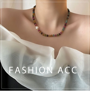 Détail d'un collier de pierres colorées avec fermoir magnétique et perle d'eau douce
