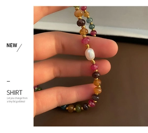 Détail d'un bracelet en pierres naturelles colorées avec perle baroque et accents dorés