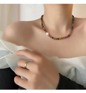 Détail d'un collier en pierres naturelles colorées avec perle d'eau douce sur modèle
