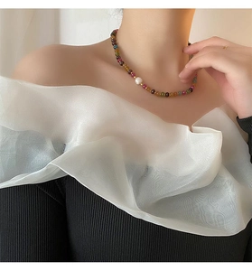 Gros plan d'un collier de pierres naturelles avec une perle blanche irrégulière