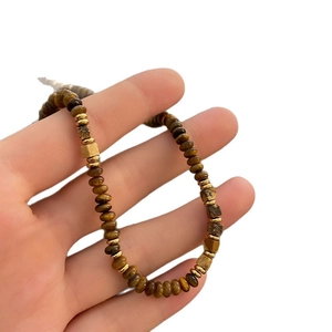 Handheld view of tiger eye beaded necklace with golden metal spacers and brown cube beads