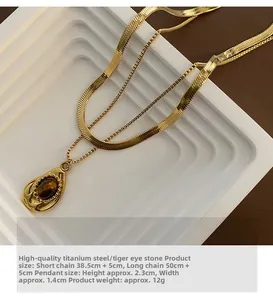 Detail of double-layer titanium steel necklace with tiger eye stone teardrop pendant