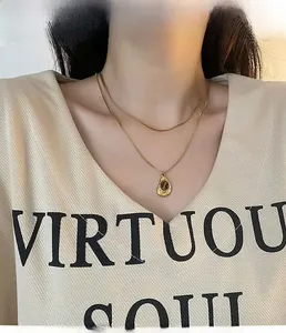 Double-layered gold titanium necklace with a water-drop tiger eye pendant on a model