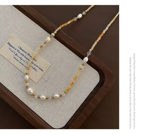 Detail of natural freshwater pearls and warm yellow beads on a bohemian beaded necklace