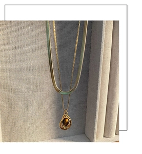 Close-up of double layer gold necklace with water drop tiger eye stone pendant