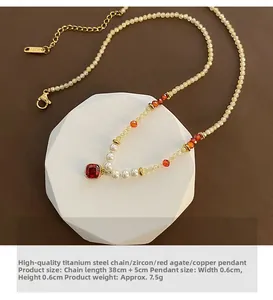 Détail du collier de perles naturelles avec pendentif en agate rouge et chaîne en titane