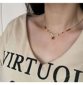 Détail d'un collier de perles avec pendentif rubis et perles blanches sur mannequin