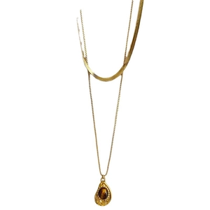 Gold double-layered titanium necklace with tiger eye stone pendant on white background