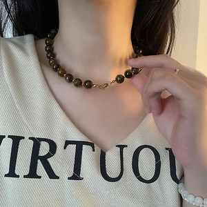 Tiger eye bead necklace with gold spacers and spring clasp on a female model neck