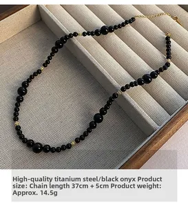 Detail of black agate bead necklace with gold titanium steel spacers and extension chain