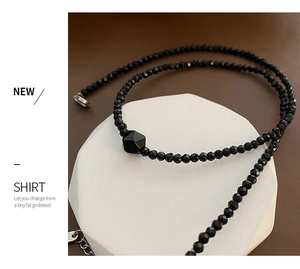 Close-up of black faceted agate beads with a geometric centerpiece and silver clasp