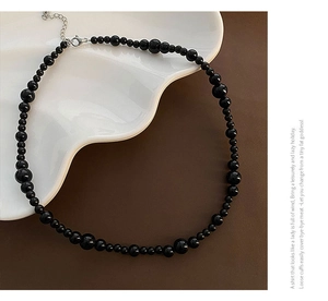 Detail of black onyx beaded necklace with alternating sizes and silver clasp