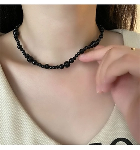 Detail of beaded black onyx necklace showing gradient pearl size on neck model