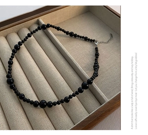 Detail of gradient black agate beads with silver lobster clasp and extension chain