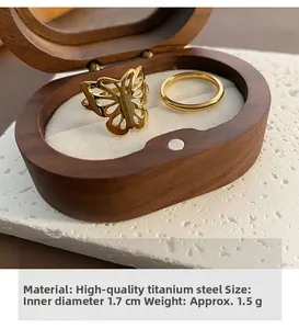 Detail of two-piece hollow butterfly 18k gold plated titanium ring set in jewelry box