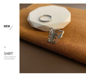 Macro detail of silver hollow butterfly ring set with stacked minimalist bands