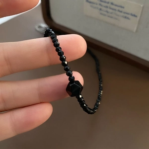 Minimalist black faceted onyx beaded necklace featuring a geometric accent stone