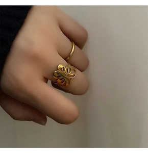 Detail of 18k gold plated hollow butterfly ring and simple band set on model's hand
