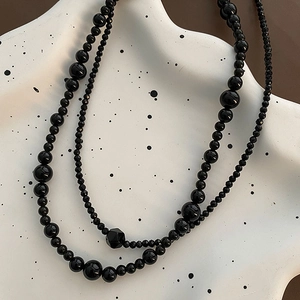 Elegant multi-layered black beaded necklace featuring polished round and faceted beads