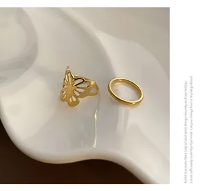 Detail view of 18k gold butterfly ring set with hollow design on white ceramic tray