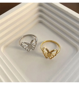 Detail of hollow butterfly rings in gold and silver finish with elegant cutout design