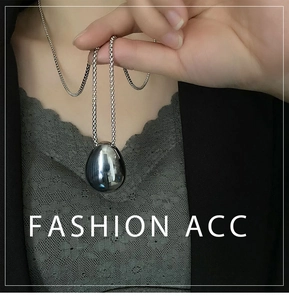 Polished silver teardrop pendant necklace in titanium steel on a black suit jacket