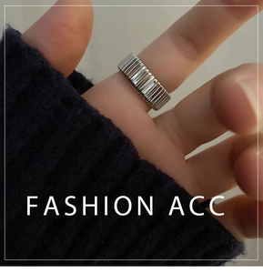 Detailed view of silver pleated titanium steel wide ring with industrial fold texture