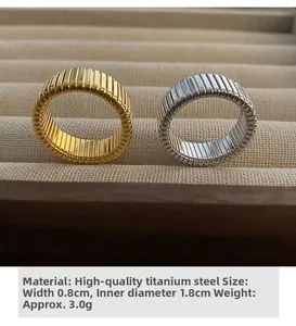 Detailed view of gold and silver textured titanium steel rings in a velvet jewelry box