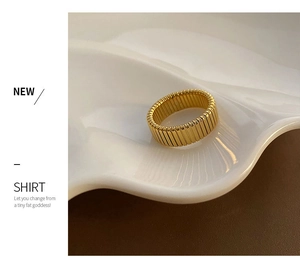 Detailed view of vintage gold textured wide band ring on a white ceramic tray