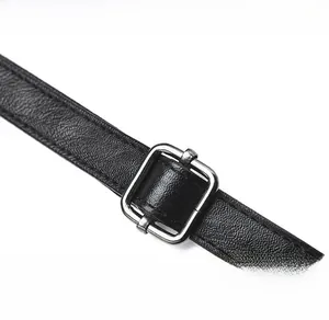 Detail of black leather shoulder strap with adjustable silver metal buckle and fine stitching