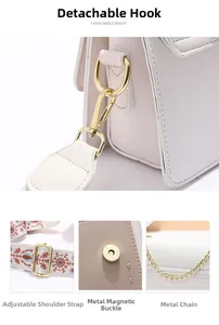 Détails du sac bandoulière beige avec bandoulière brodée et fermoirs métalliques