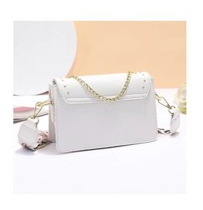 Gros plan d'un sac bandoulière blanc avec chaîne dorée et sangle large stylée