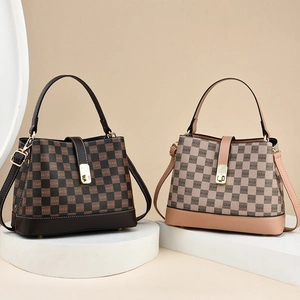 Chic monogrammed bucket handbag in brown and khaki leather with top handles and gold buckle