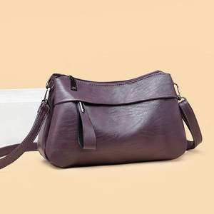 Elegant purple leather shoulder bag with pebbled texture and metal zipper closure