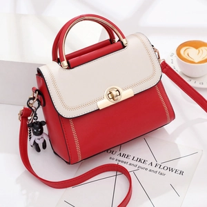 Red and white two-tone handbag with golden clasp and cute black bear charm accessory