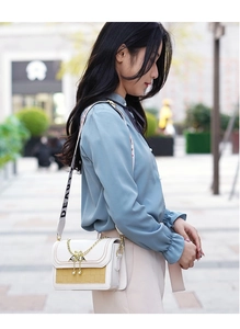 Vue latérale du sac bandoulière en cuir blanc et jaune avec chaîne et sangle à logo