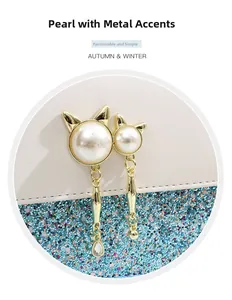 Detail of pearl and metal hardware decor on a white and blue sequined crossbody bag