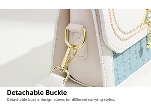 Détail du fermoir en métal doré amovible sur un sac à main en cuir rose et bleu ciel
